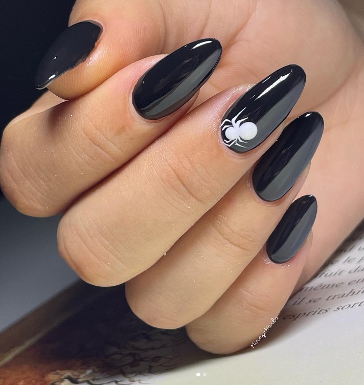 classy black nail ideas with a white spider